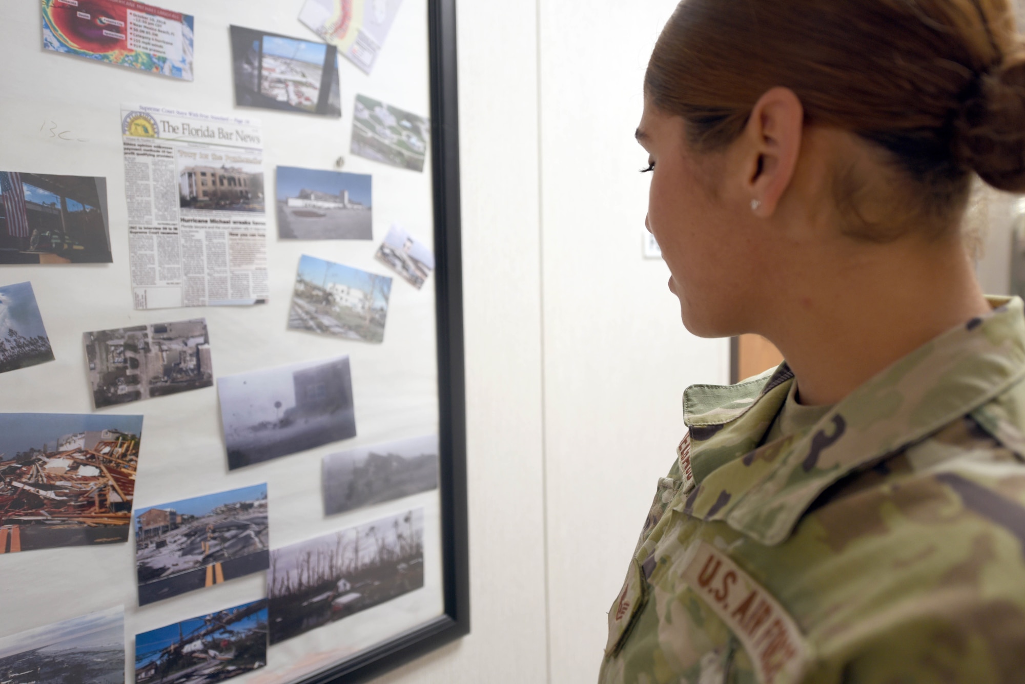 Airman looks at photos from after Hurricane Michael