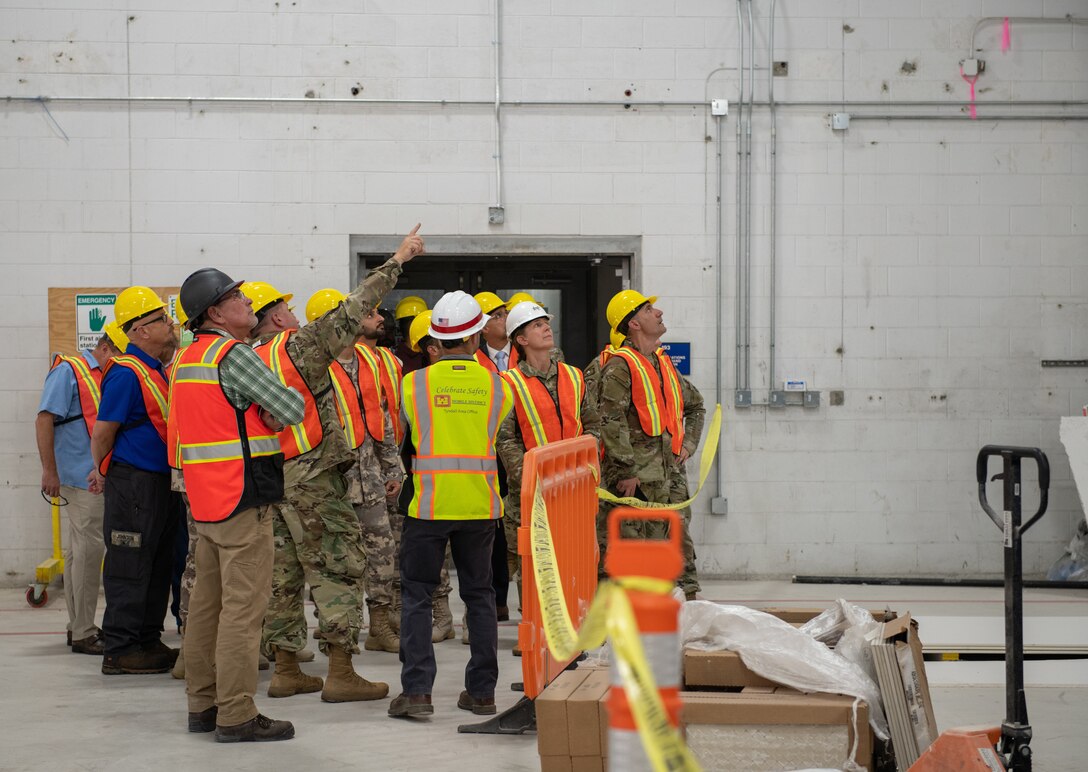 Members of the Qatar Emiri Corps of Engineers, U.S Army, U.S. Air Force and Tyndall Air Force Base rebuild partners examine new hangar roofing during a distinguished visitors tour at Tyndall Air Force Base, Florida, June 9, 2022. Members of the distinguished visitors tour visited Building 290 to understand the strategic importance of hangar, enhancements and Engineer Research and Development Center technology. (U.S. Air Force photo by Airman 1st Class Zachary Nordheim)