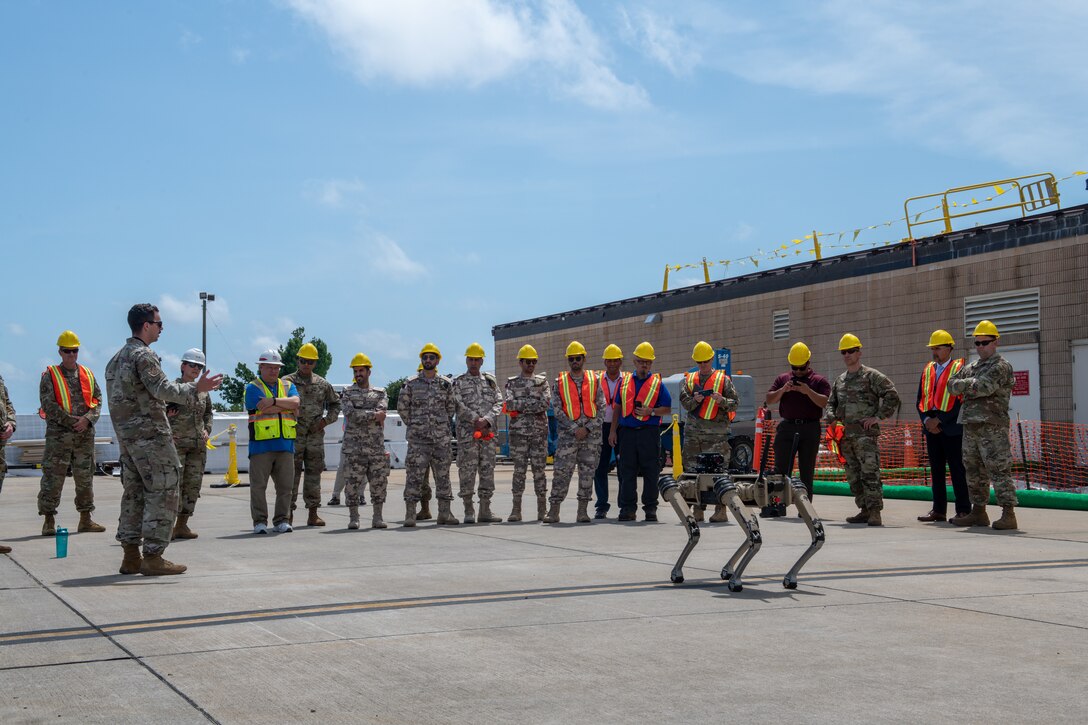 Members of the Qatar Emiri Corps of Engineers, U.S Army, U.S. Air Force and Tyndall Air Force Base rebuild partners discuss Tyndall Air Force Base logistics during a distinguished visitors tour at Tyndall Air Force Base, Florida, June 9, 2022. The Quad-legged Unmanned Ground Vehicles are a small portion of innovation to help accelerate the change seen at Tyndall. (U.S. Air Force photo by Airman 1st Class Nordheim)