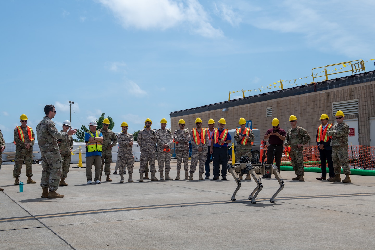 Members of the Qatar Emiri Corps of Engineers, U.S Army, U.S. Air Force and Tyndall Air Force Base rebuild partners discuss Tyndall Air Force Base logistics during a distinguished visitors tour at Tyndall Air Force Base, Florida, June 9, 2022. The Quad-legged Unmanned Ground Vehicles are a small portion of innovation to help accelerate the change seen at Tyndall. (U.S. Air Force photo by Airman 1st Class Nordheim)