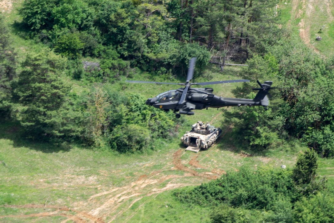 A helicopter flies over trees.