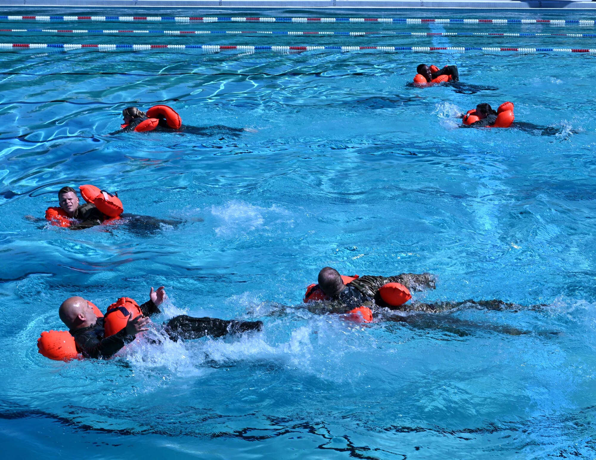 members use flotation devices in a pool