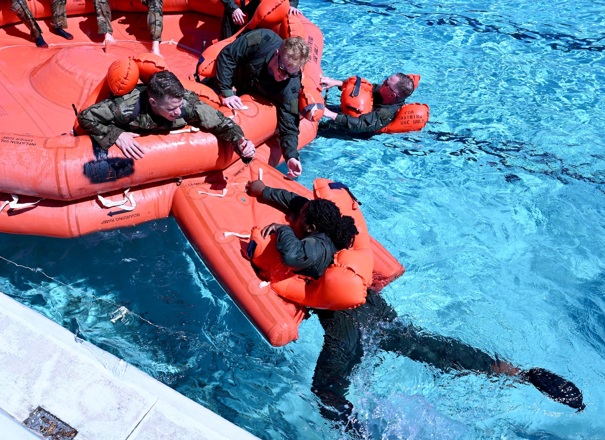 members pull someone onto a flotation device