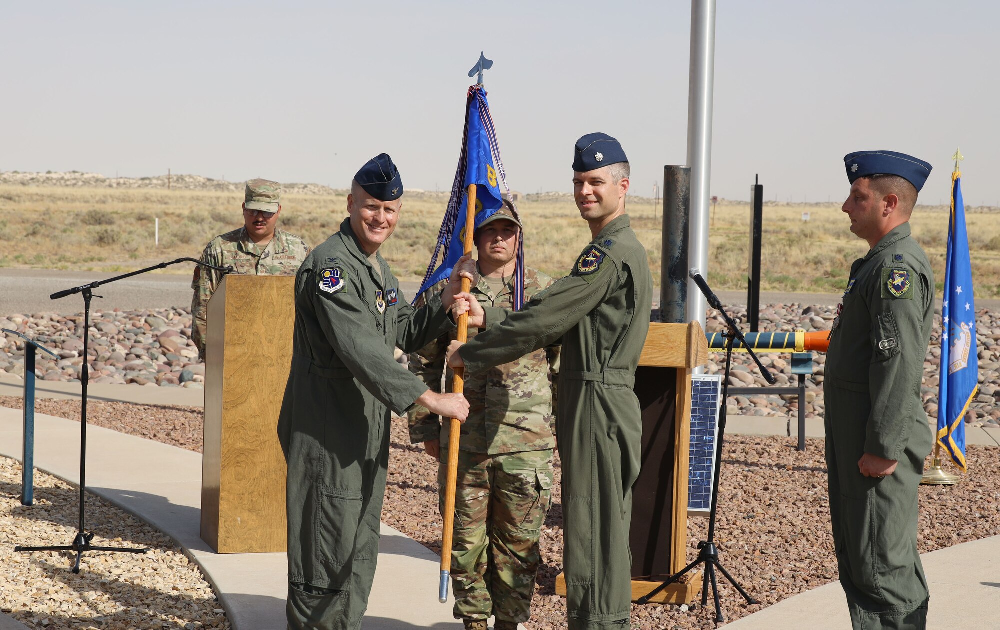 Lt. Col. Jared Rupp, second from right, and Col. Darren Wees, 704th Test Group commander, second from left, pose for a photo after Rupp accepted the guidon for the 846th Test Squadron from Wees during a Change of Command ceremony June 9, 2022, at the Holloman High Speed Test Track on Holloman Air Force Base, N.M. Rupp assumed command of the 846 TS, the squadron that operates the HHSTT. The mission of the 846 TS is to plan and execute world-class rocket sled tests enabling weapon system development in support of the warfighter. The squadron is part of the 704th Test Group at Holloman, a unit of Arnold Engineering Development Complex, headquartered at Arnold Air Force Base, Tenn. (U.S. Air Force photo by Philip Cooksey)