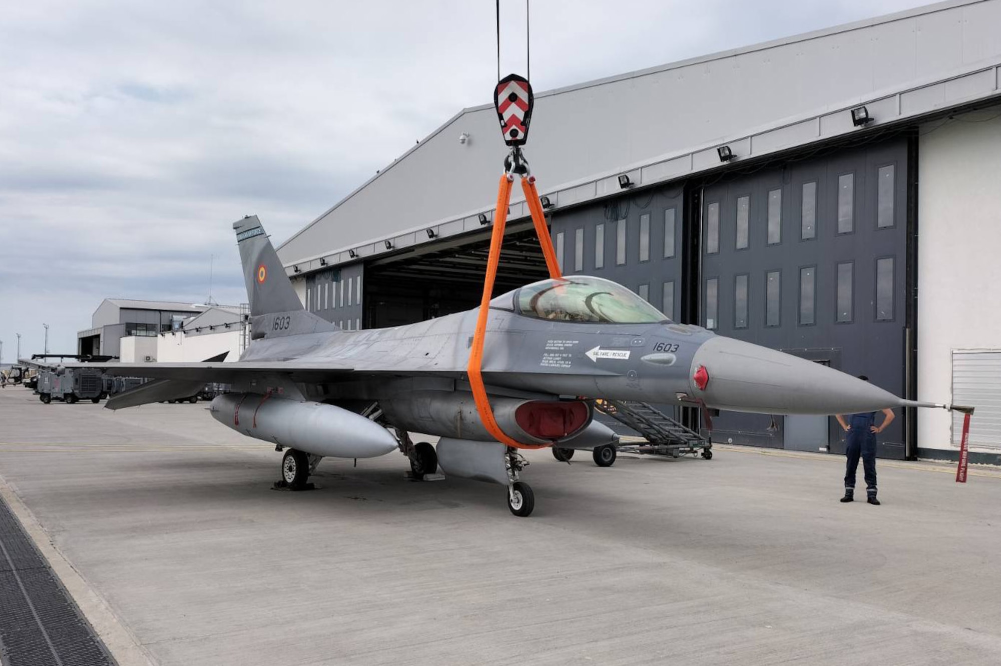 U.S. Airmen from the 31st Maintenance Group and maintainers from the Romanian air force successfully attach a sling and belly band to an F-16 Fighting Falcon