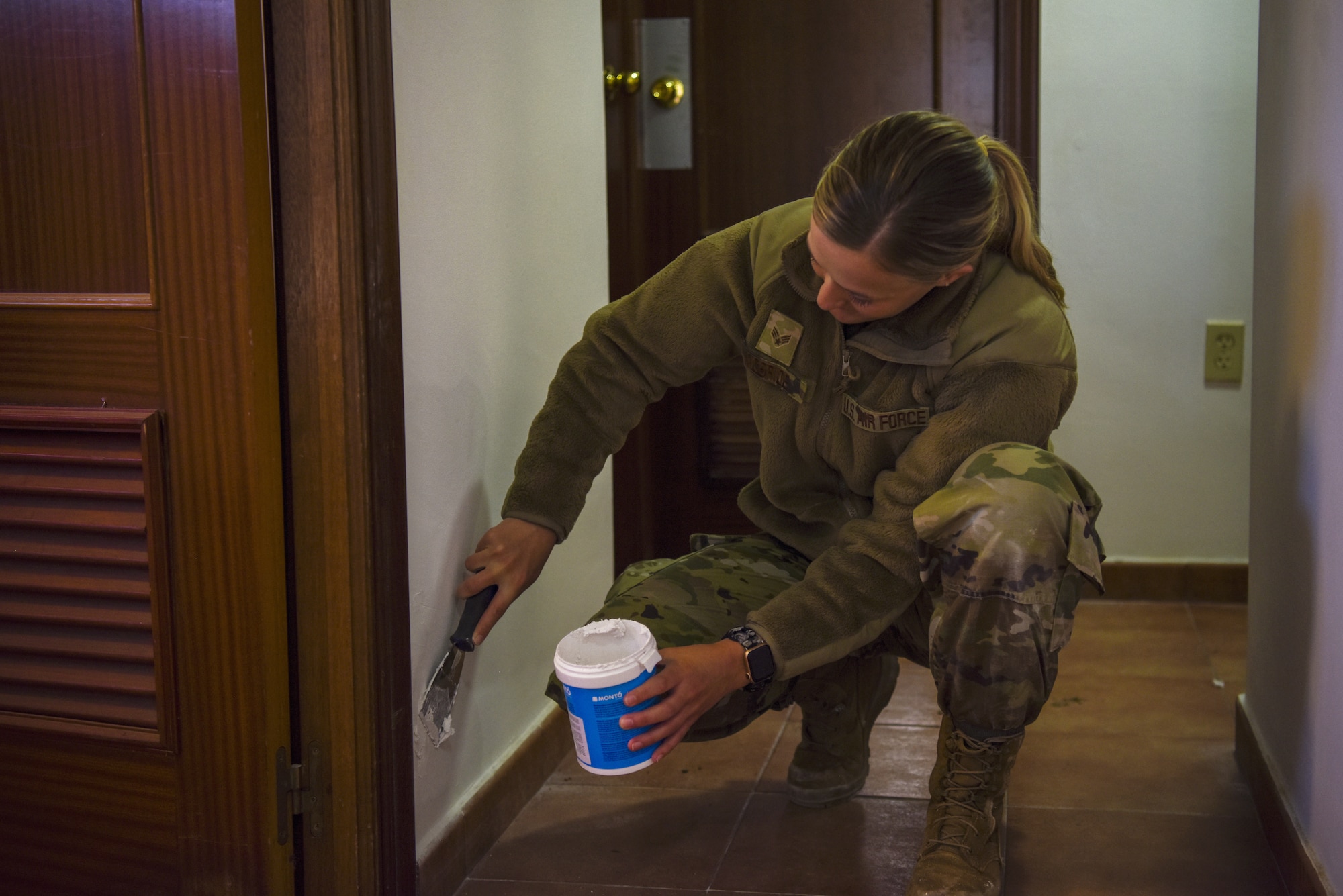 U.S. Air Force Senior Airman Mara McBride, 911th Civil Engineer Squadron engineering apprentice, applies dry wall putty on a house that recently suffered water damage on Morón Air Base, Spain, April 1, 2022.