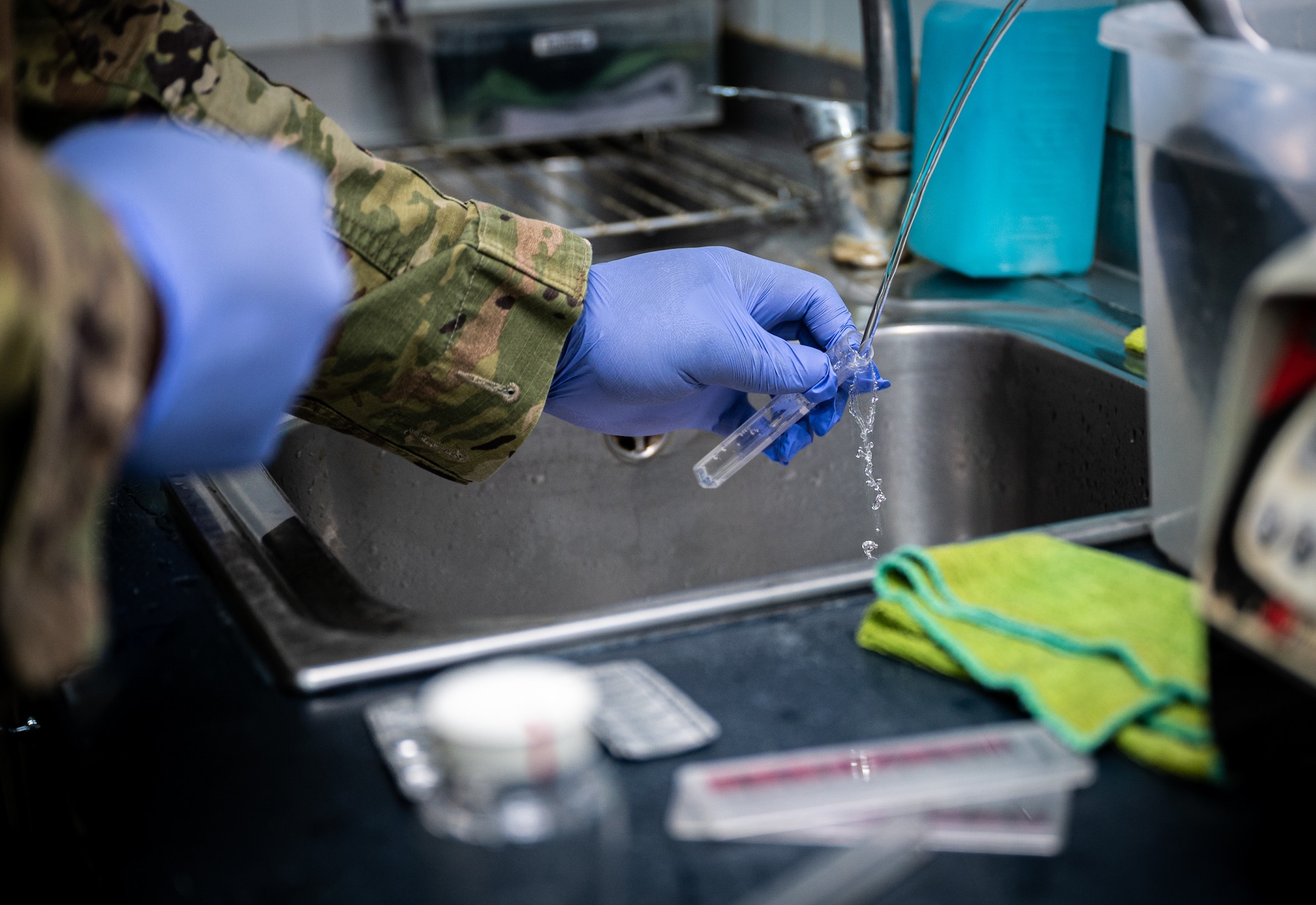 Senior Airman Kevin Thompson, 332d Expeditionary Civil Engineer Squadron force protection and public health journeyman, gathers a water sample at an on-base coffee shop to test for acceptable ranges in pH and chlorine at an undisclosed location in Southwest Asia, May 11, 2022. (U.S. Air Force photo by Master Sgt. Christopher Parr)