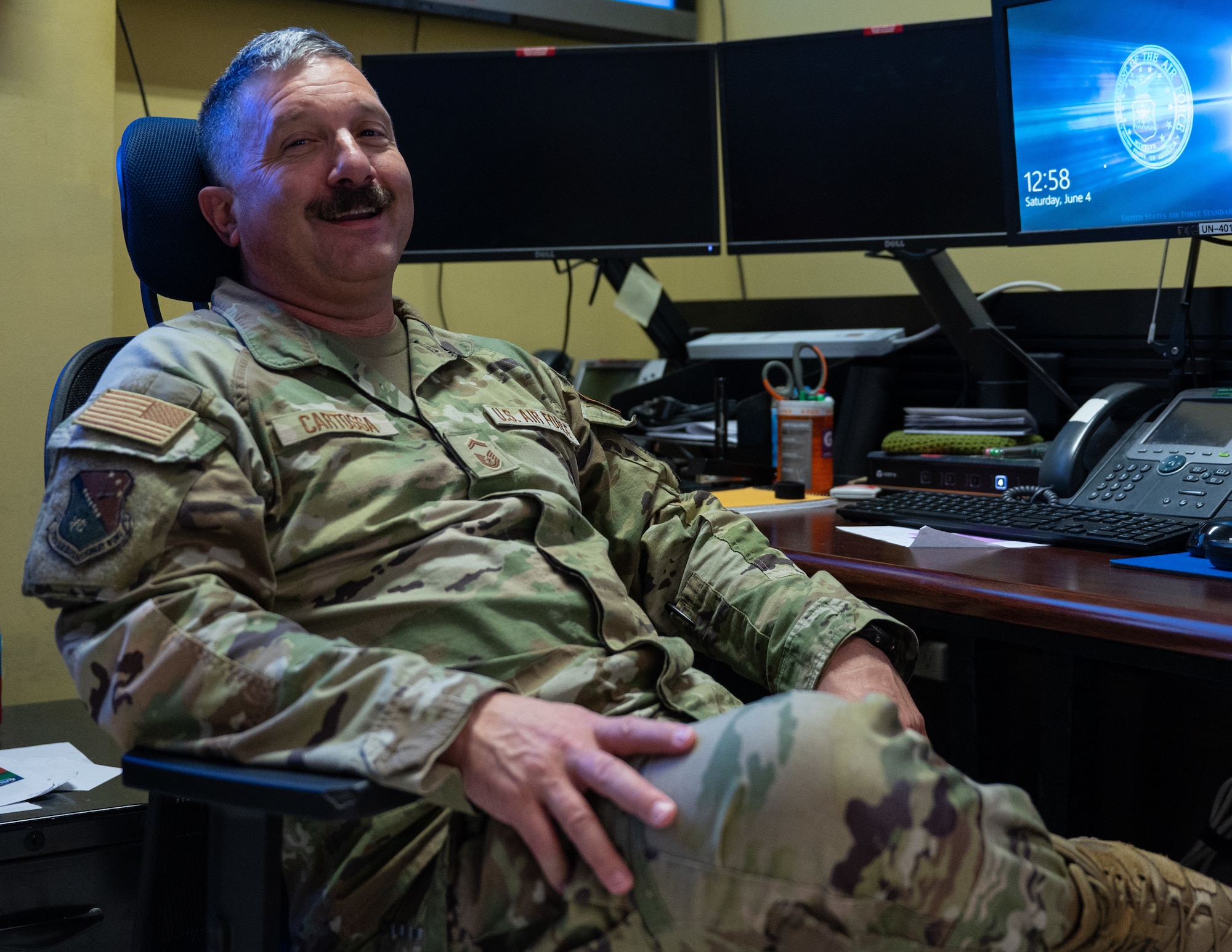 U.S. Air Force Senior Master Sgt. Edward Cartossa, command and control (C2) operations specialist assigned to the 379th Air Expeditionary Wing, Al Udeid Air Base, Qatar, sits in the AUAB C2 office in the Wing Operation Center to talk about his mission, during Accurate Test 22 at Thumrait Air Base, Oman, June 4, 2022.  Cartossa’s C2 operations team employed missile strike early warning capabilities, for the first time, in a combat environment while forward deployed to Oman in May 2022. (U.S. Air Force photo by Staff Sgt. Dana Tourtellotte)