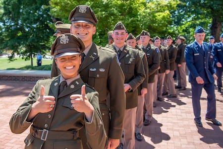 Young Soldiers in formal green uniforms pose, standing in a line.