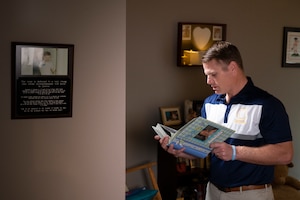 Christopher Schlachter Sr., looks through photo books in a room dedicated to the memory of his son, Christopher Schlachter Jr., in O'Fallon, Illinois, June 10, 2022. In order to carry on his legacy, Schlachter Sr. started the Christopher Jr. Legacy for Drowning Prevention program in 2016 in partnership with the YMCA in O’Fallon and since its inception, the program have provided swimming lessons and educated over a thousand families on proper water safety and prevention. (U.S. Air Force photo by Staff Sgt. Dalton Williams)