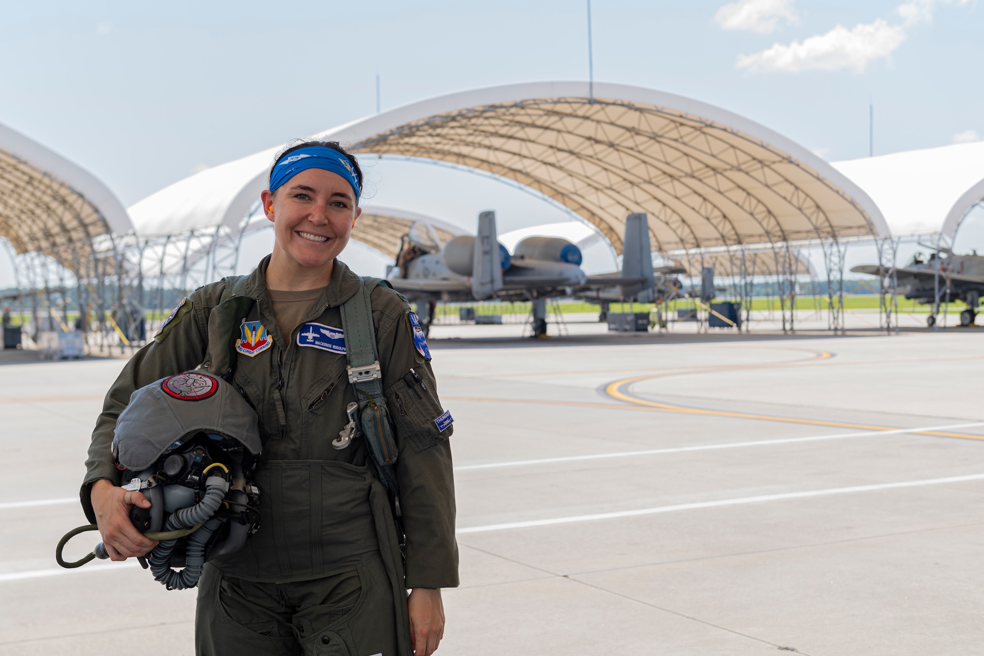 U.S. Air Force 1st Lt. Mackenzie Rudolph, 74th Fighter Squadron A-10 Thunderbolt II pilot, poses with her helmet after a flight at Moody Air Force Base, Georgia, June 2, 2022. During air-to-air combat or while maneuvering the aircraft, the constant weight of an approximate 10-pound helmet and the added G force can potentially cause neck and spinal strain. (U.S. Air Force photo by Senior Airman Jasmine Barnes)