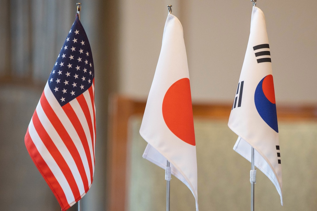 Miniature U.S., Japanese and South Korean flags stand in a row.