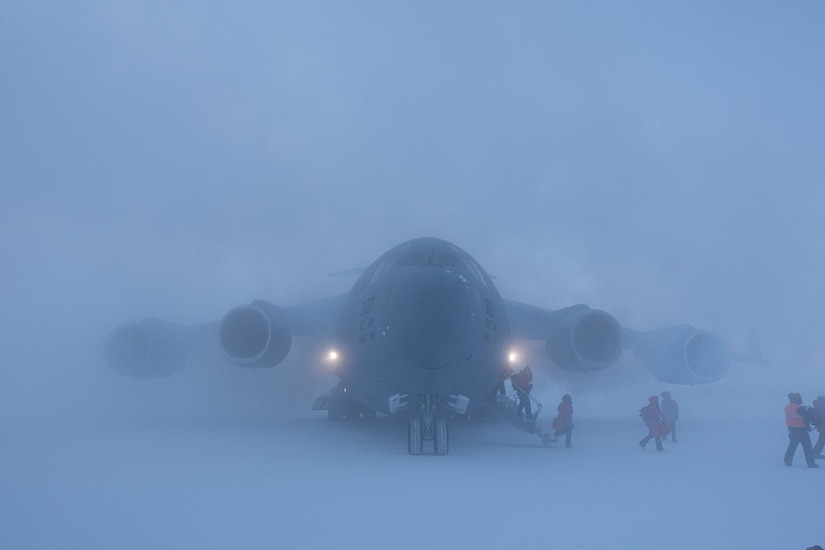 Passengers disembark an aircraft in low visibility, heavy snow environment