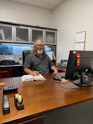 DLA Disposition Services' Environmental Specialist Kevin Sparks at his desk at the Red River Army Depot, Texarkana, TX.