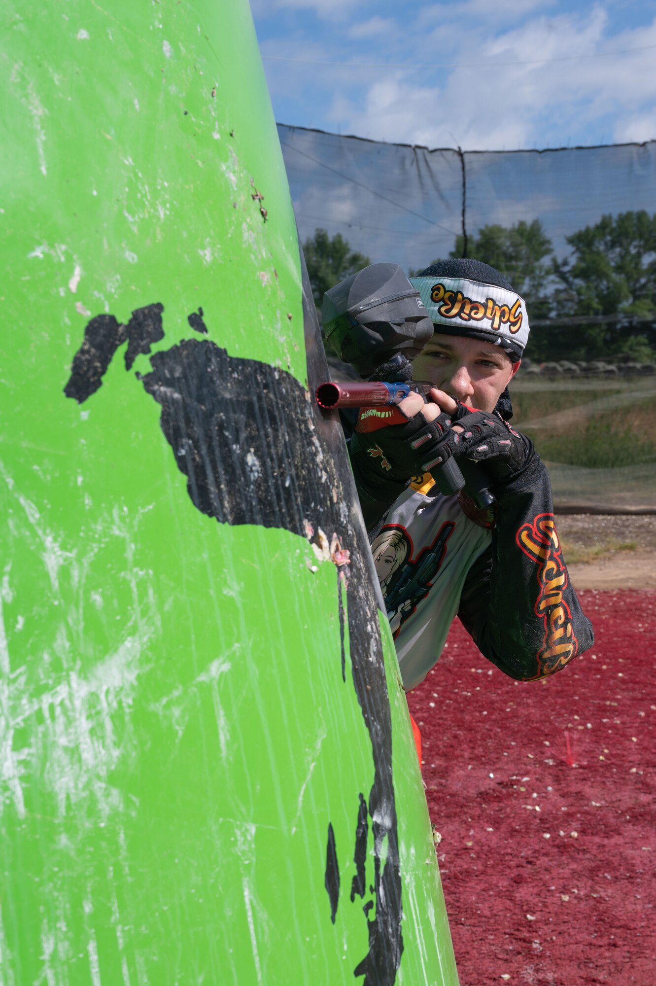 Airman 1st Class Caleb Porterfield, 736th Aircraft Maintenance C-17 Globemaster II crew chief, peaks out from the side of an inflatable barrier at a paintball field in Chesapeake City, Maryland, May 29, 2022. Porterfield competes on a Division 5 speedball team and plays the sport to stay physically active and find his “inner peace.” (U.S. Air Force photo by Airman 1st Class Cydney Lee)
