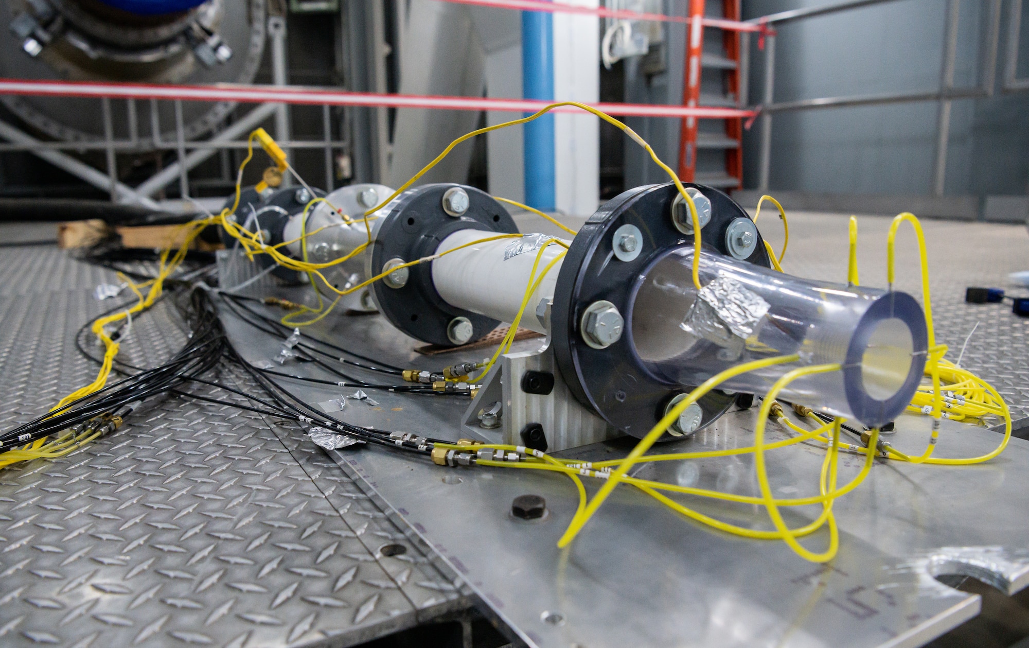 A nozzle is connected to a testing apparatus in a sea level turbine engine test cell at Arnold Air Force Base.