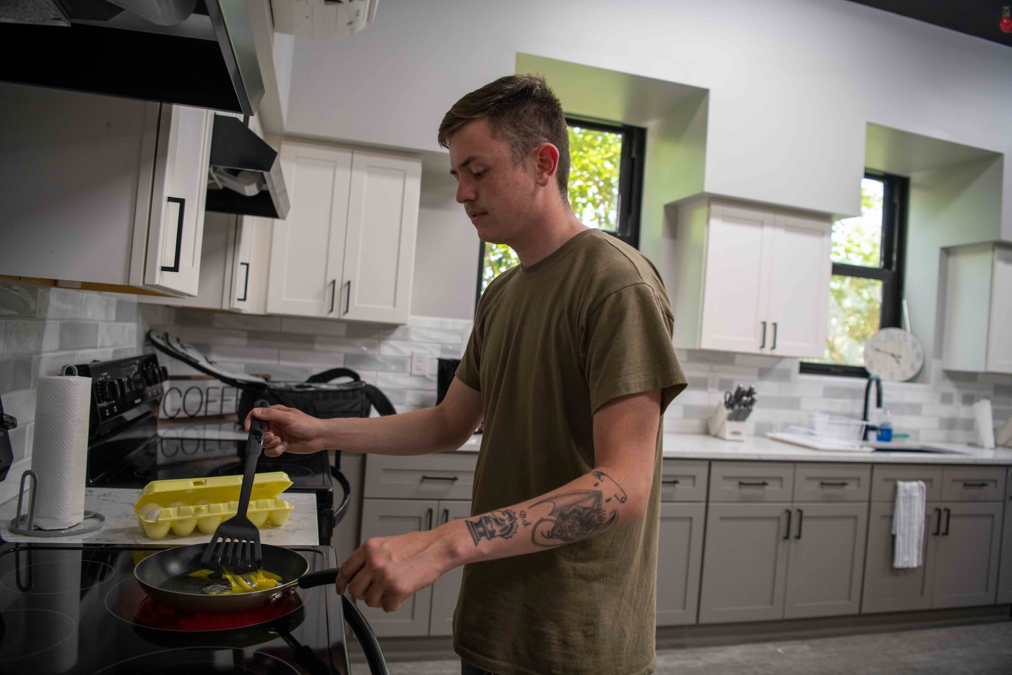 Airman James Stewart, 22nd LRS Fuels Systems Operator, cooks eggs in the newly-built kitchen that recently opened in a McConnell Dormitory June 14, 2022, at McConnell Air Force Base, Kansas. The airmen living in the dorms don't have individual kitchens, so a new communal kitchen was built. (U.S. Air Force photo by Airman William Lunn)