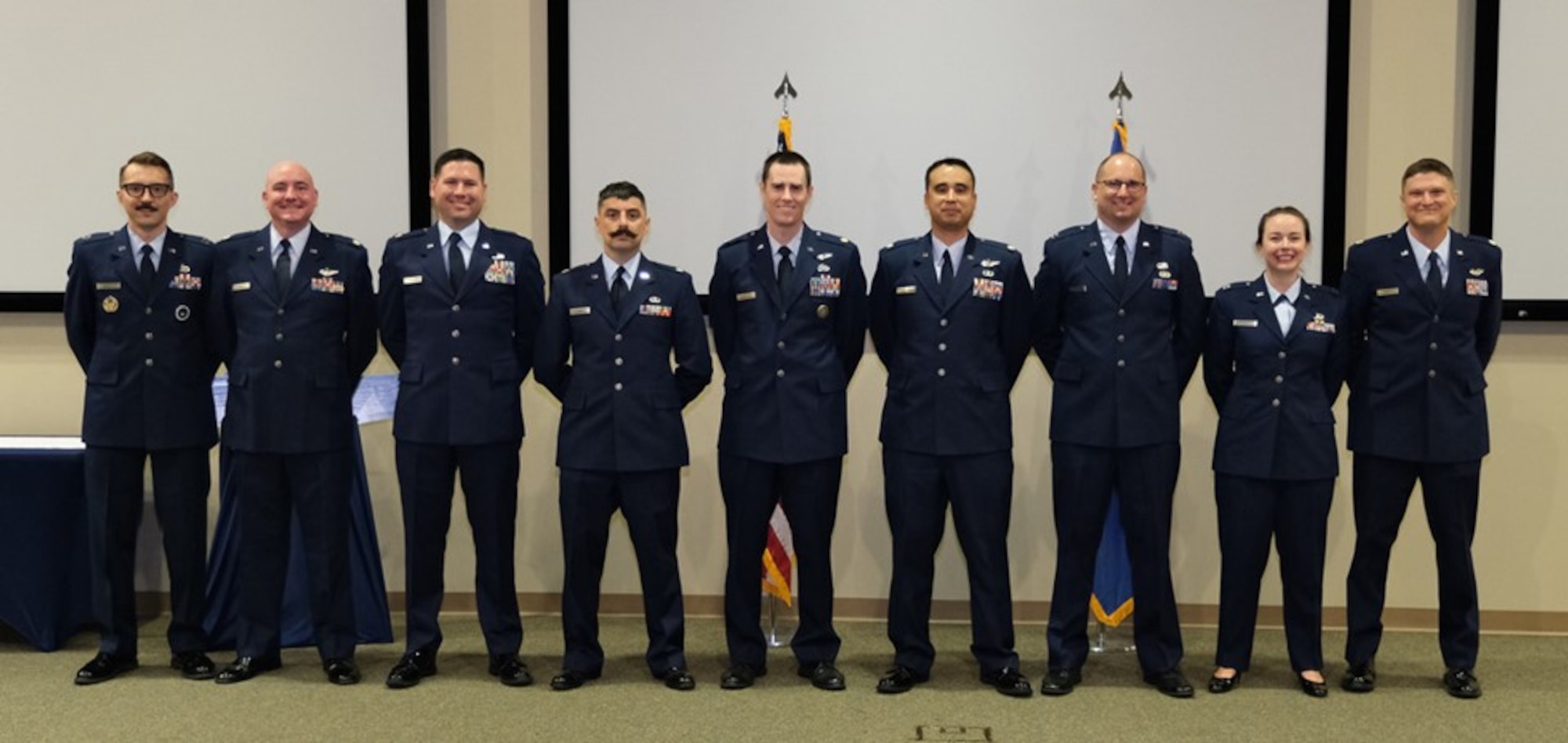 photo of nine USAF Airmen in service dress uniforms standing