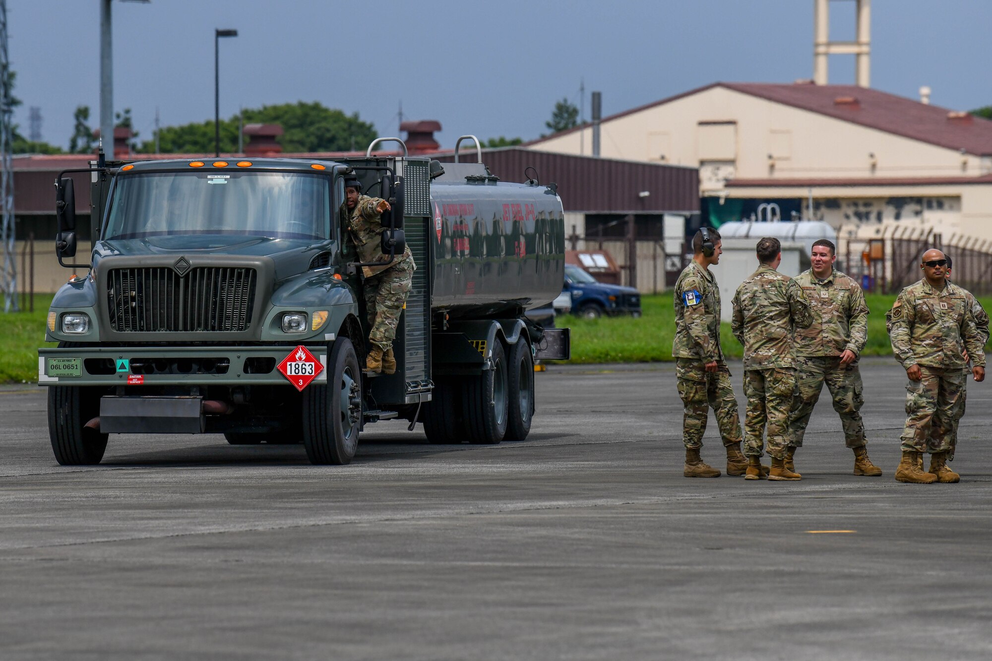 An Airman speaks with the driver of a R-11 fuel truck for a hot refuel