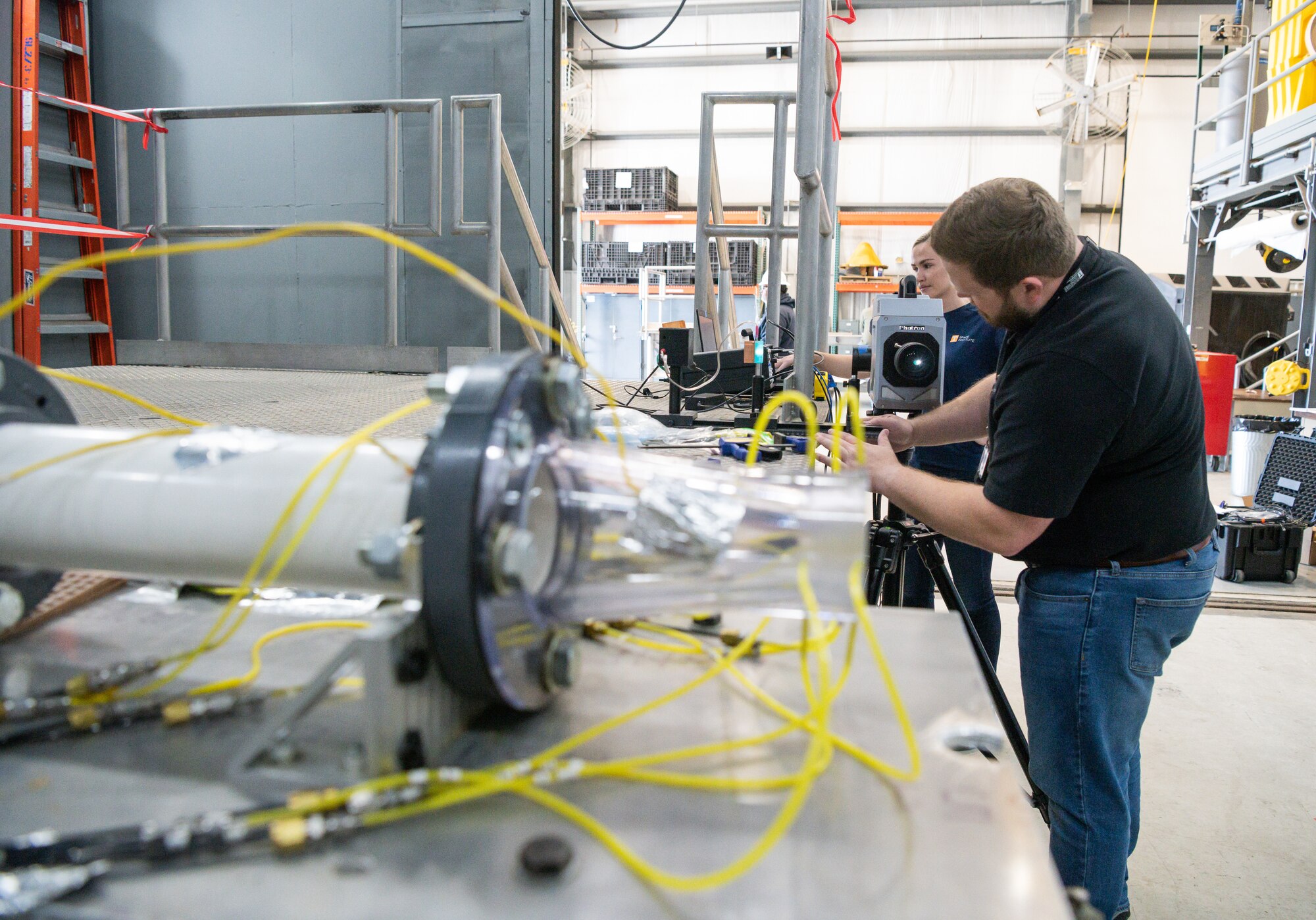 Haley Goldston and Dr. Phil Kreth, with the University of Tennessee Space Institute, set up equipment in SL-2, a sea level turbine engine test cell at Arnold Air Force Base, Tenn.,  to observe and record shadowgraph data of the air flow from various nozzles.