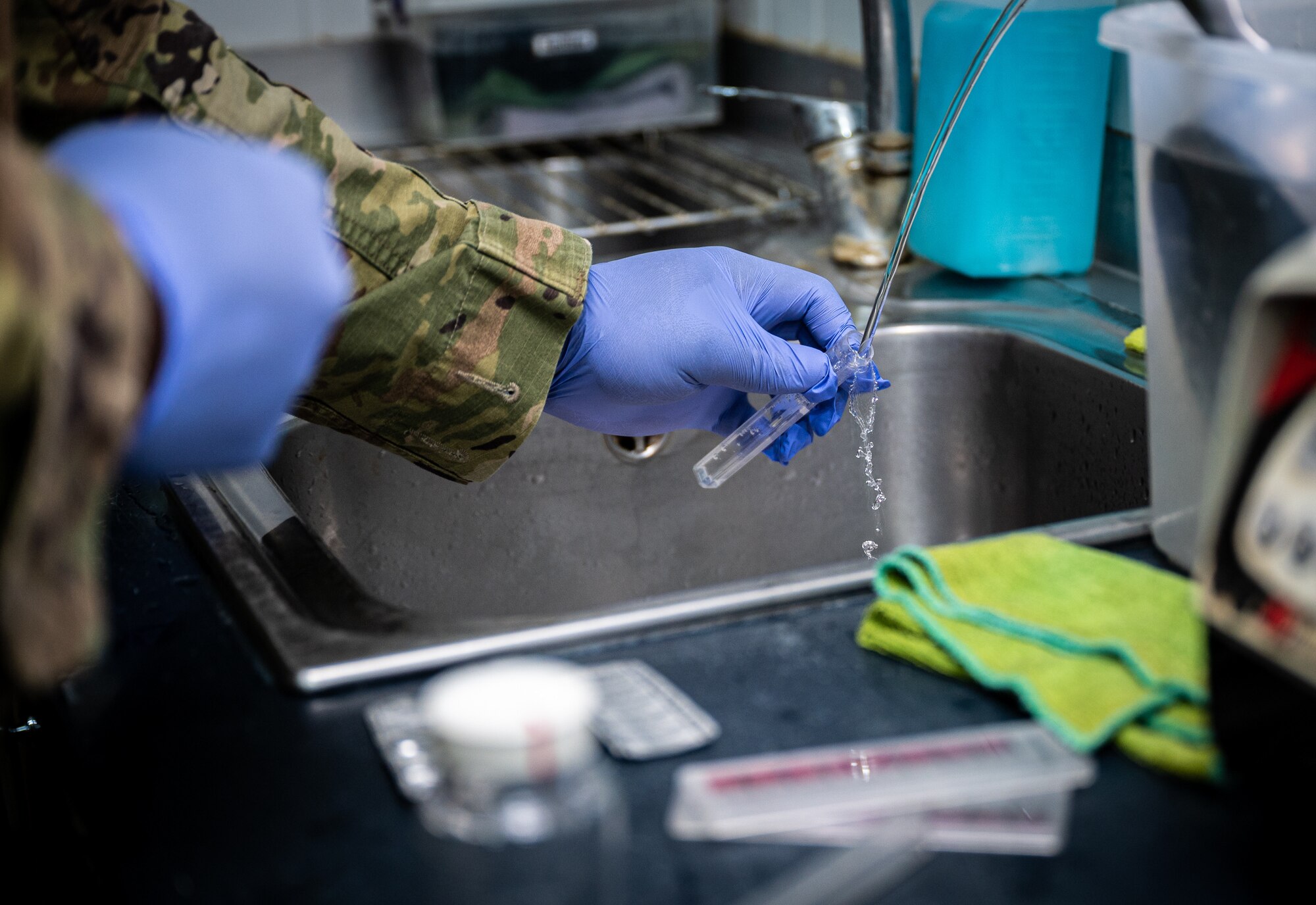 Senior Airman Kevin Thompson, 332d Expeditionary Civil Engineer Squadron force protection and public health journeyman, gathers a water sample at an on-base coffee shop to test for acceptable ranges in pH and chlorine at an undisclosed location in Southwest Asia, May 11, 2022. (U.S. Air Force photo by Master Sgt. Christopher Parr)