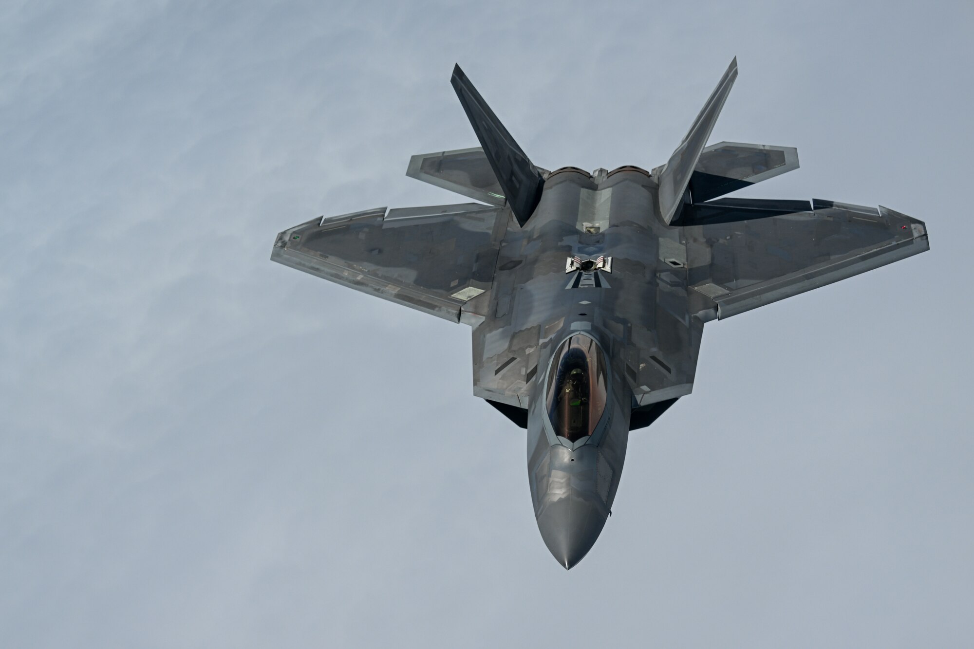 A U.S. Air Force F-22 Raptor, deployed to Kadena Air Base, Japan, approaches a KC-135 Stratotanker assigned to the 909th Air Refueling Squadron, Kadena AB, for aerial refueling, June 10, 2022. Kadena Air Base regularly hosts visiting joint, allied and partner forces to conduct missions to enhance our operational readiness to defend Japan and ensure a free-and-open Indo-Pacific. (U.S. Air Force photo by Tech. Sgt. Corban Lundborg)