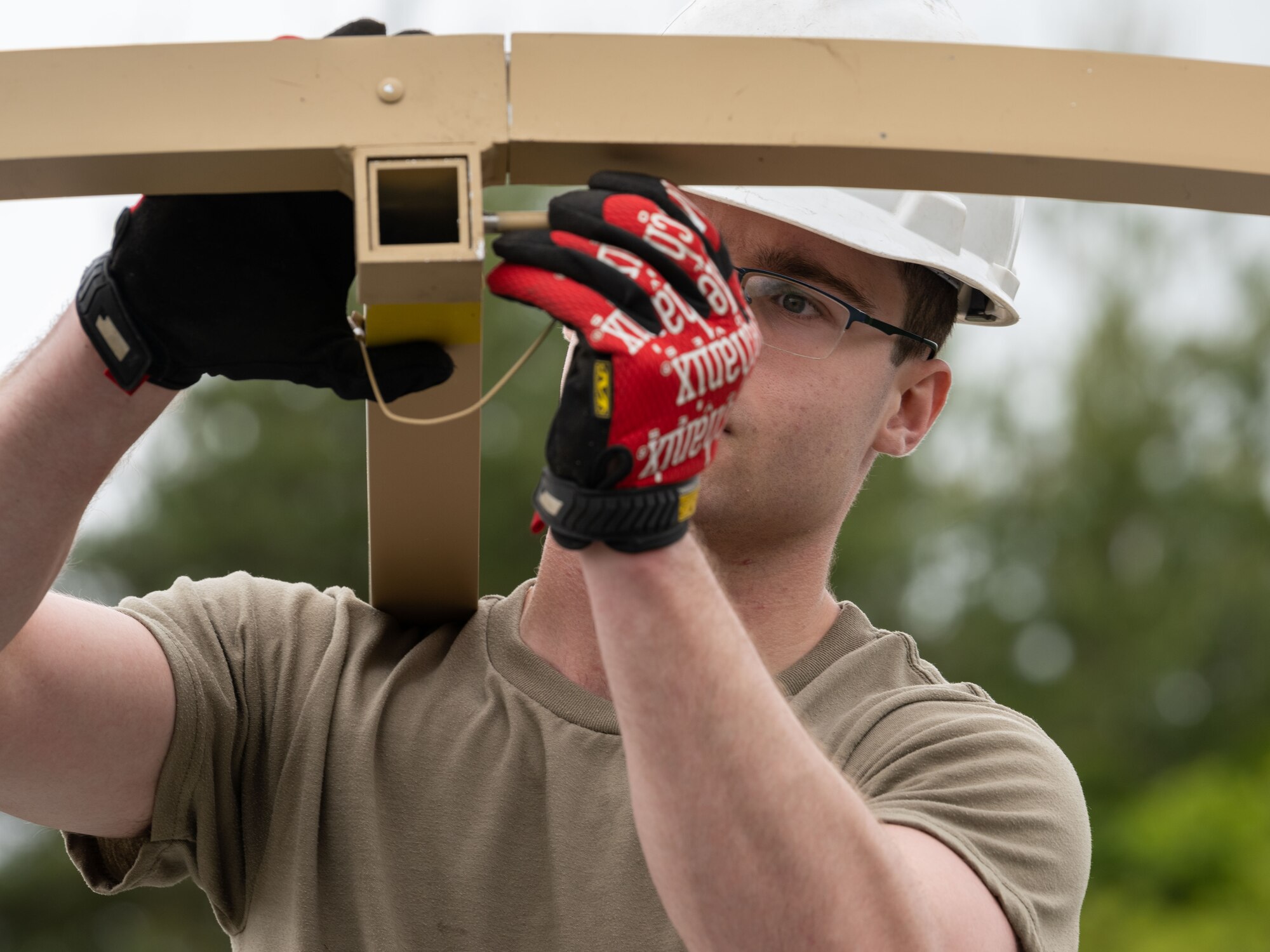 U.S. Airman 1st Class Ryan Gray, 35th Civil Engineer Squadron structures journeyman, places a pin to connect and lock a Disaster Relief Beddown System tent during the annual Prime Base Engineer Emergency Force (Prime BEEF) training at Misawa Air Base, Japan, June 14, 2022.