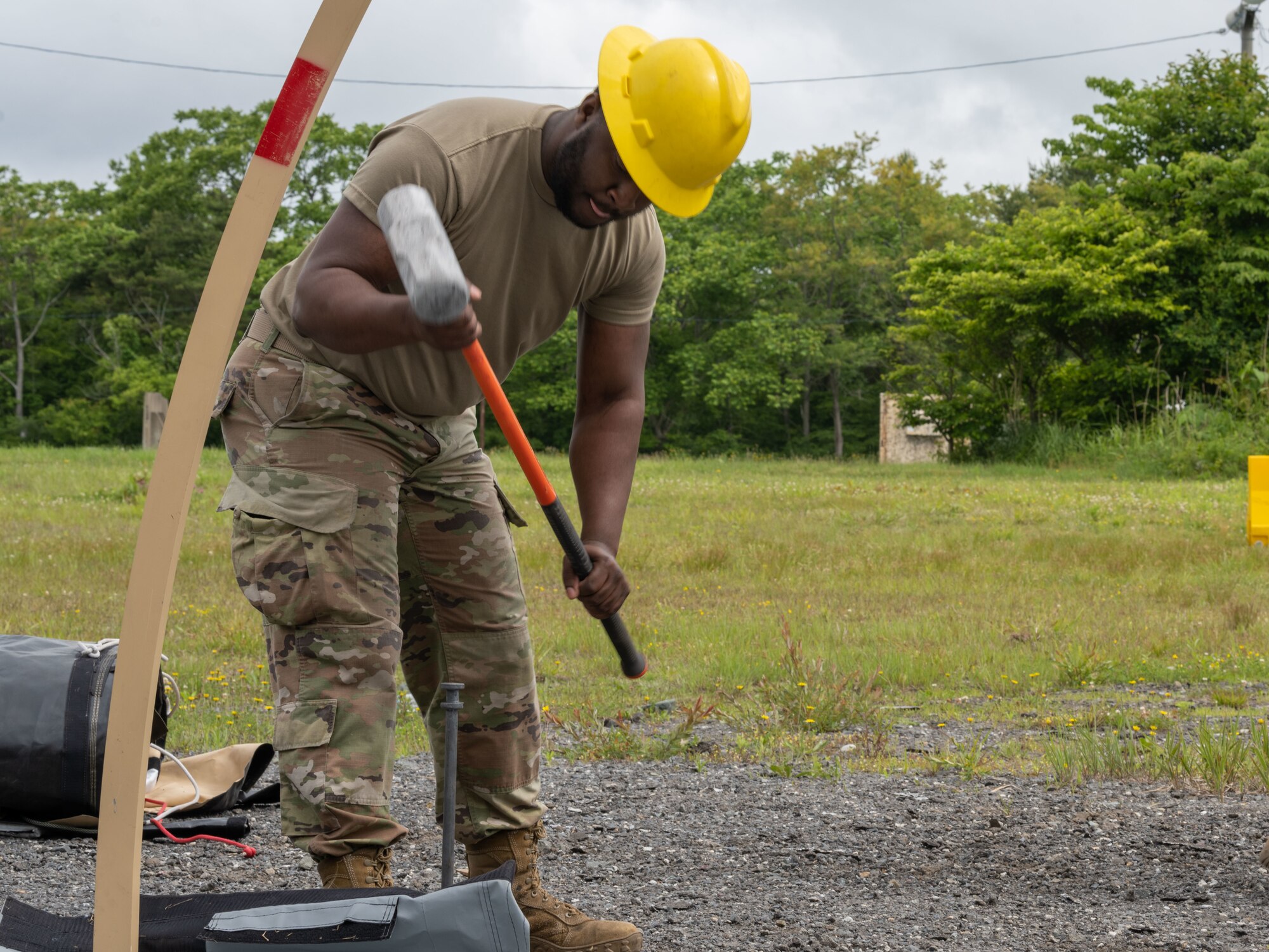 U.S. Airman 1st Class Kyrin Brown, 35th Civil Engineer Squadron water and fuels system maintainer, stakes a Disaster Relief Beddown System (DRBS) tent down during the annual Prime Base Engineer Emergency Force training at Misawa Air Base, Japan, June 14, 2022.
