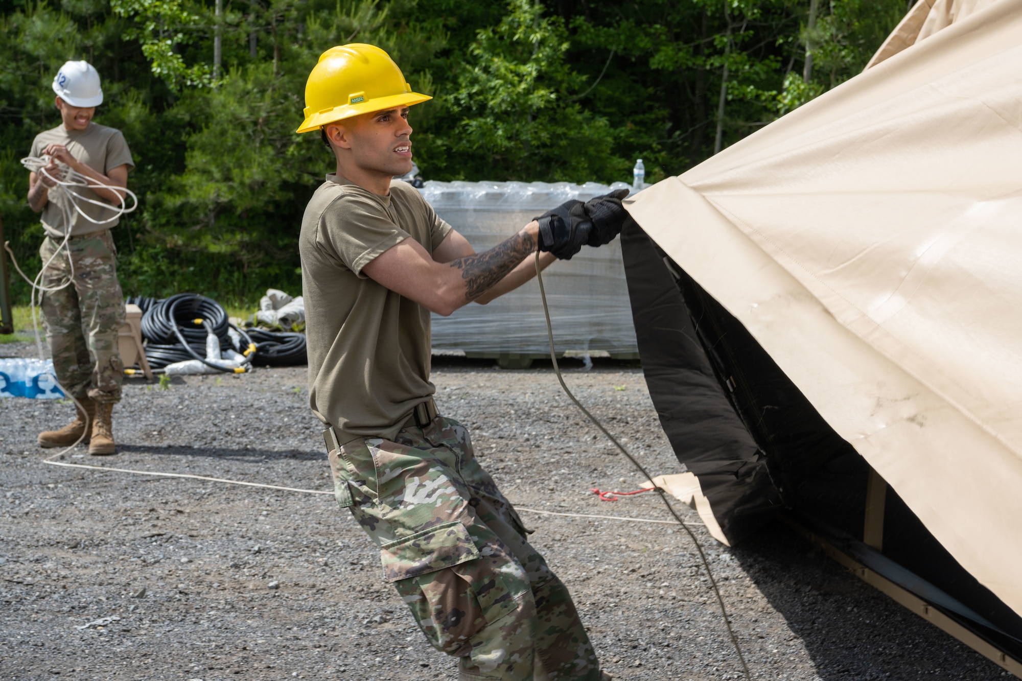 U.S. Air Force Senior Airman Aaron Ferraro, 35th Civil Engineer Squadron integrated industrial control systems technician, pulls over the top of a Disaster Relief Beddown System tent during the annual Prime Base Engineer Emergency Force (Prime BEEF) training at Misawa Air Base, Japan, June 14, 2022.