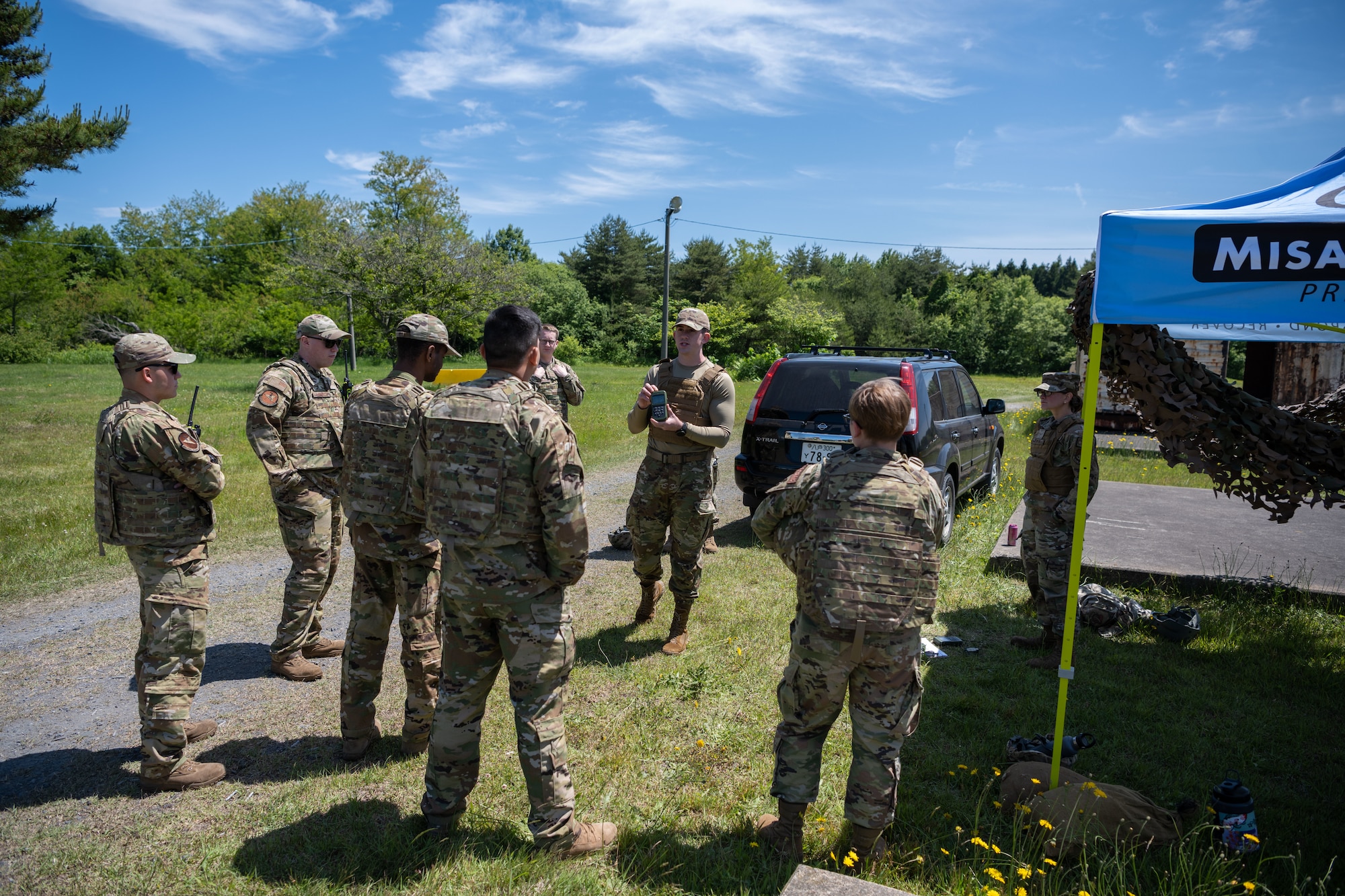 U.S. Air Force Senior Airman Gabriel Meyer, center, and Airman 1st Class Miranda Demers, right, 35th Civil Engineer Squadron emergency management journeymen, explain the tools required for the land navigation course during the annual Prime Base Engineer Emergency Force training at Misawa Air Base, Japan, June 14, 2022.