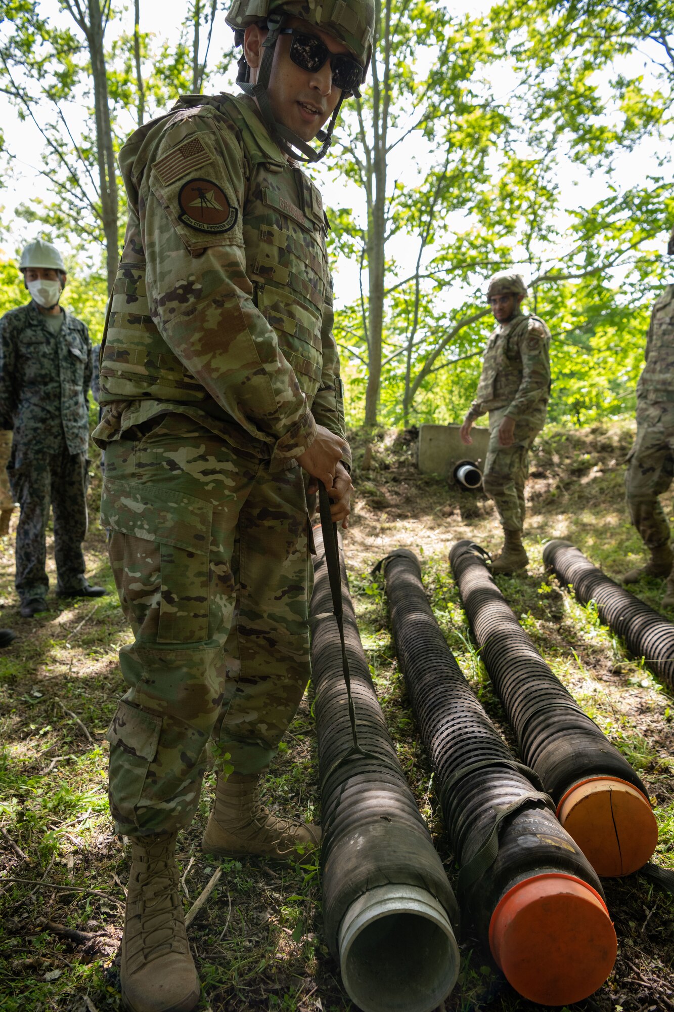 U.S. Air Force Tech. Sgt. Jaime Gracias, 35th Civil Engineer Squadron (CES) water and fuel system craftsman, moves pipes for the Water and Fuel Expedient Repair System (WaFERS), during the annual Prime Base Engineer Emergency Force training at Misawa Air Base, Japan, June 14, 2022.