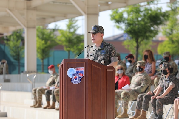 Gen. Won In-choul in uniform stands at podium providing remarks during a farewell ceremony at Barker Field.