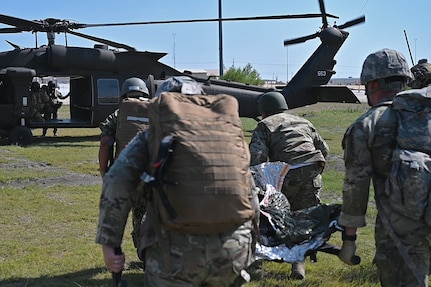 Joint medical learners participating in a aeromedical care course transport a simulated casualty to a UH-60 Black Hawk helicopter, 1-244th Assault Helicopter Battalion, Louisiana Army National Guard, during the 2022 Joint Emergency Medicine Exercise at Fort Hood, Texas, June 9, 2022. The JEMX hosted by the Carl R. Darnall Army Medical Center brought together over 2,000 service members from across the services to train medical personnel in combat casualty care, aeromedical care and forward resuscitation surgical team care.