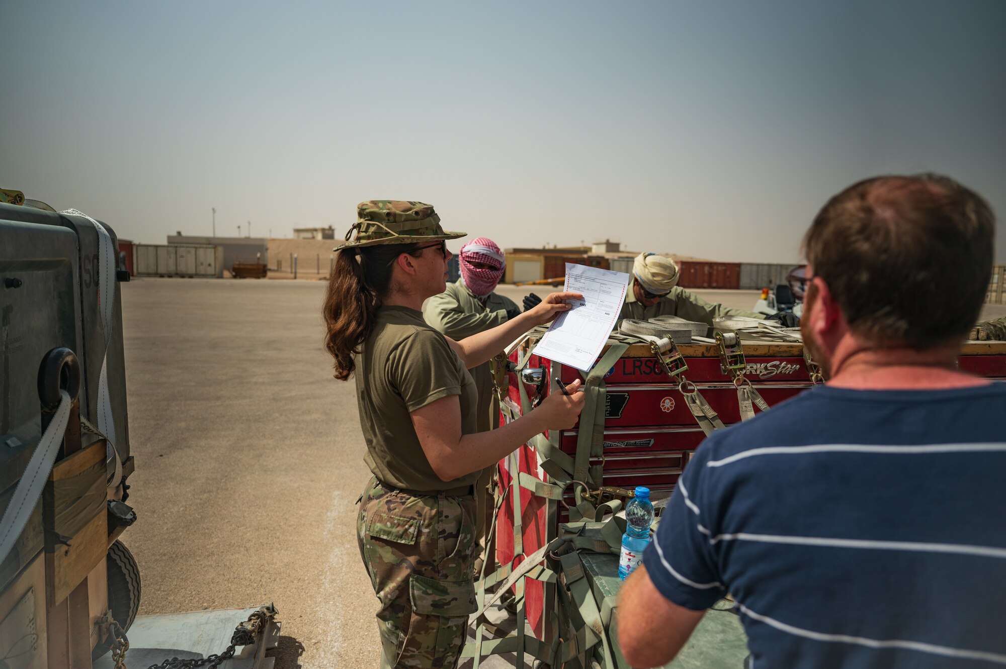 U.S. Air Force Staff Sgt. Miranda Shaw, forward deployed from the 379th Air Expeditionary Logistics Readiness Squadron, Al Udeid Air Base, Qatar, signs for outbound cargo in preparation for a departure flight during exercise Accurate Test 22 at Thumrait Air Base, Oman, May 22, 2022. Her inspections helped ensure that the cargo was properly inspected and marked for shipment to its intended destination. (U.S. Air Force photo by Staff Sgt. Dana Tourtellotte)
