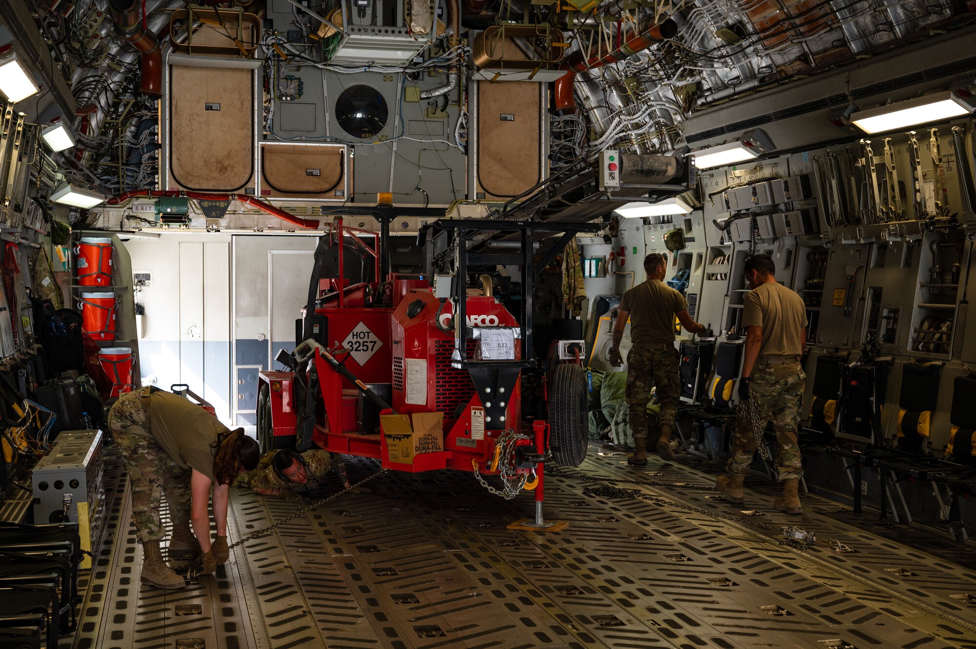 U.S. Air Force Airmen from the 379th Air Expeditionary Wing tie down machinery in a U.S. Air Force C-17 Globemaster in preparation for a departure flight during exercise Accurate Test 22 at Thumrait Air Base, Oman, May 22, 2022. Properly securing heavy cargo and equipment prior to takeoff helps prevent in-flight shifting that can cause airborne instability and compromise passenger safety.” (U.S. Air Force photo by Staff Sgt. Dana Tourtellotte)