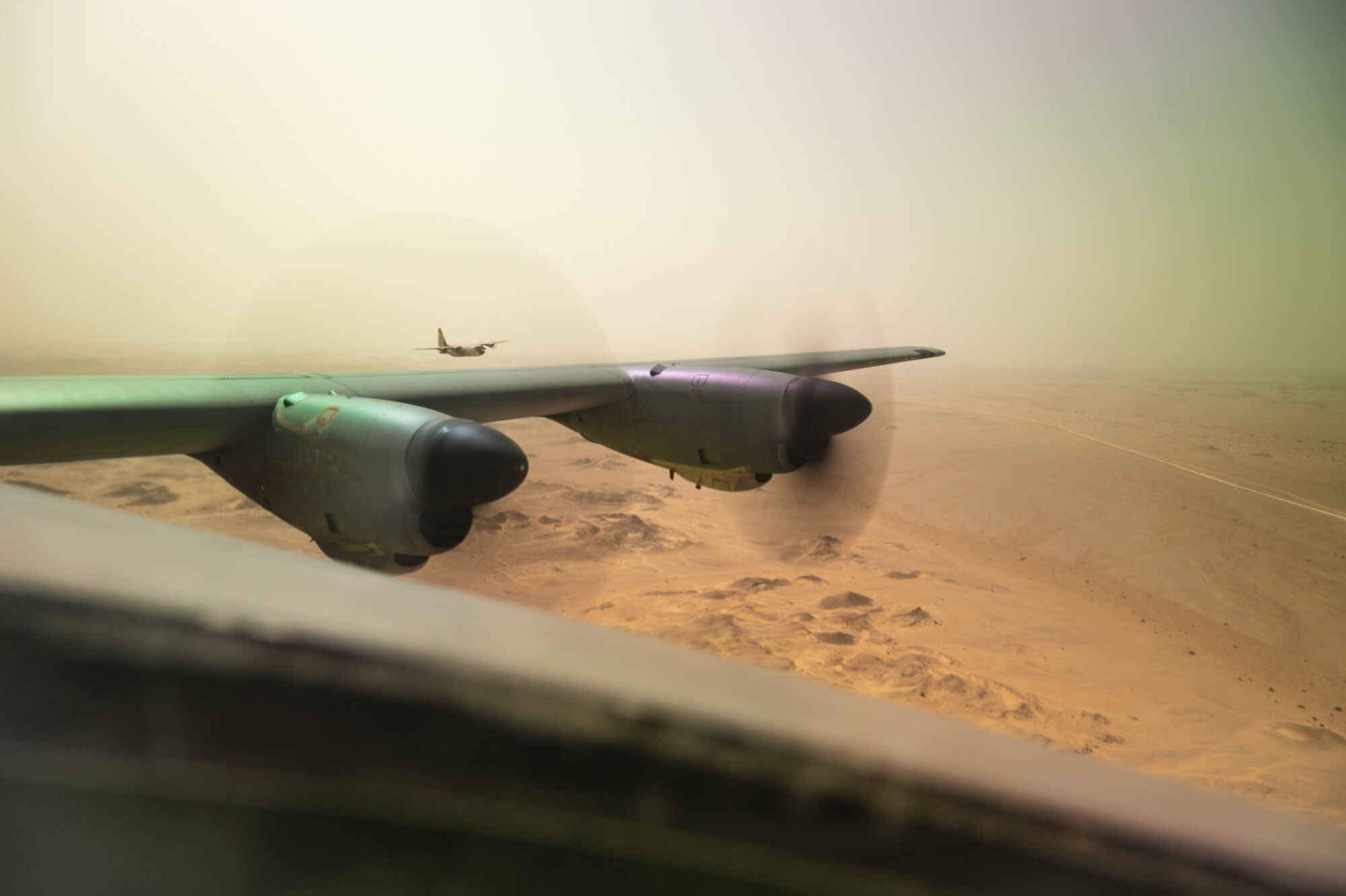 A U.S. C-130J Super Hercules aircraft assigned to the 41st Expeditionary Airlift Squadron flies in a combat exercise alongside a Royal Air Force of Oman C-130 aircraft during Accurate Test 22, May 19, 2022. While simulating low altitude evasive maneuvers, the U.S. C-130 was chased by a formation flight of RAFO fighter aircraft and a RAFO C-130. (U.S. Air Force photo by Staff Sgt. Dana Tourtellotte)