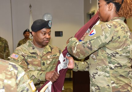 Army Medical Logistics Command senior enlisted leader Sgt. Maj. Akram Shaheed passes the unit colors to color bearer Sgt. 1st Class Courtney Price-Davis during a change of responsibility ceremony at Fort Detrick, Maryland on June 14. Shaheed assumed responsibility from outgoing senior enlisted leader Sgt. Major Monnet Bushner. (Ellen Crown)