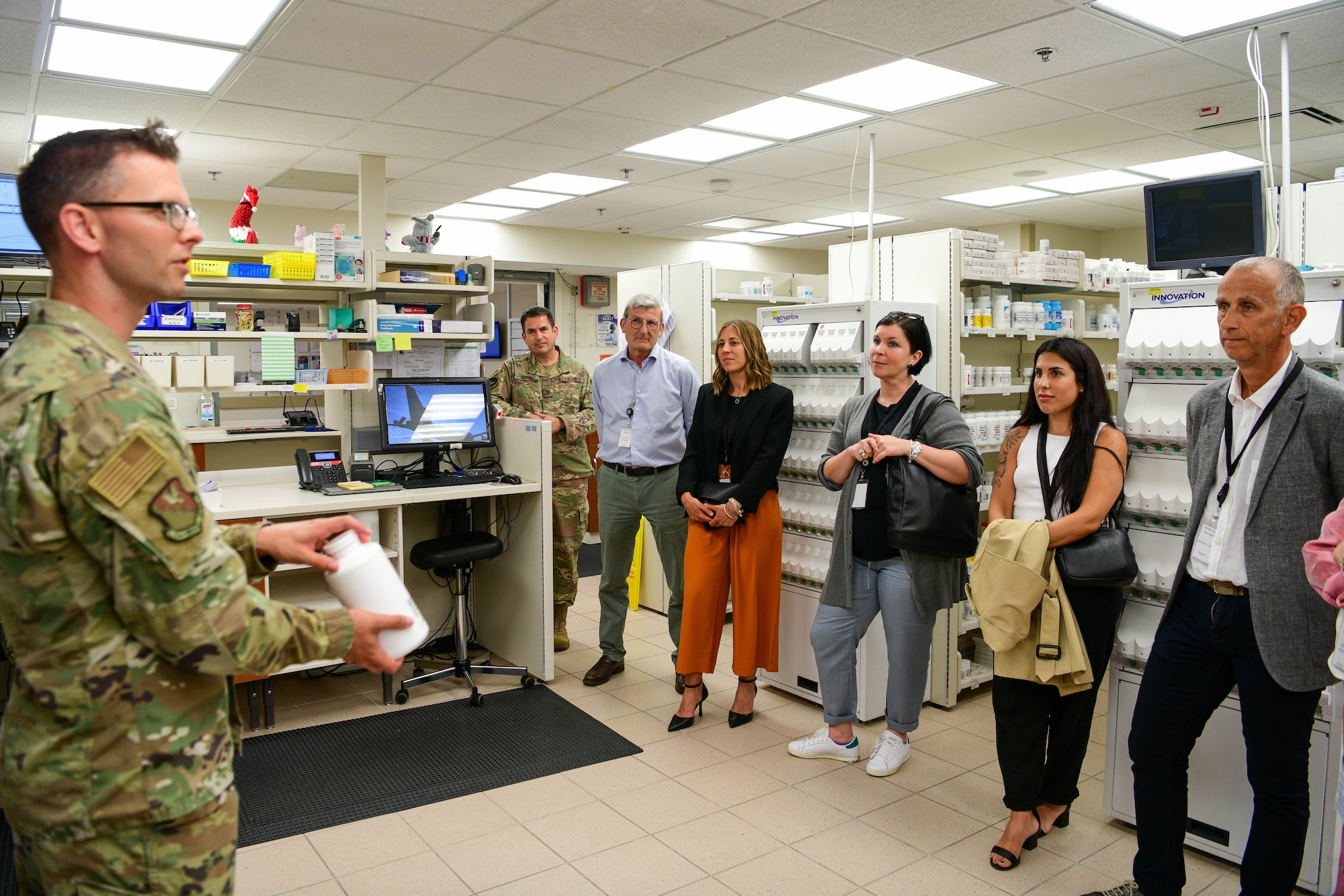U.S. Air Force Capt. Benjamin Irmen, 31st Medical Group executive officer, left, briefs local Italian host nation providers on 31st MDG pharmacy operations during a 31st MDG Open House event at Aviano Air Base, Italy, June 9, 2022. During the event host nation partners toured different parts of the 31st MDG facilities and learned about the 31st MDG mission: to supply agile trusted care, sustain ready medics and provide a premier patient experience. (U.S. Air Force photo by Senior Airman Brooke Moeder)