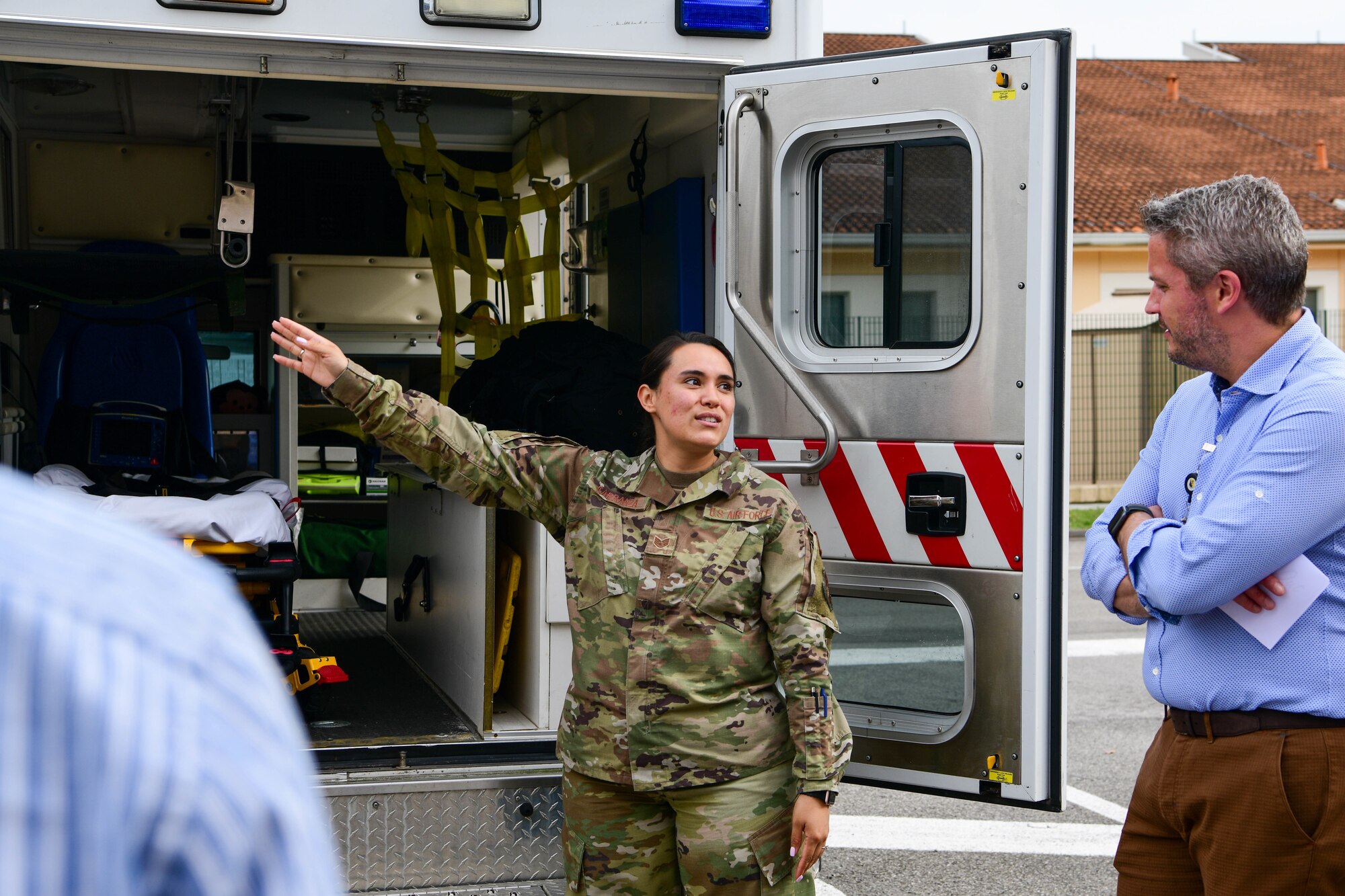 U.S. Air Force Staff Sgt. Kimberly Carranza, 31st Medical Operation Squadron ambulance services technician, left, briefs Italian host nation providers on 31st MDG ambulance services operations at a 31st MDG Open House event at Aviano Air Base, Italy, June 9, 2022. During the event, host nation partners toured different parts of the 31st MDG facilities and learned about the 31st MDG mission: to supply agile trusted care, sustain ready medics and provide a premier patient experience. (U.S. Air Force photo by Senior Airman Brooke Moeder)