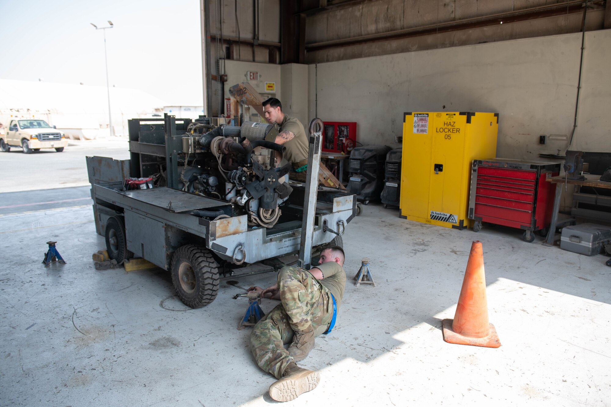 U.S. Air Force Staff Sgt. Jason Szurlej and U.S. Air Force Airman 1st Class Cameron Waters, 379th Air Expeditionary Wing Aerospace Ground Equipment Specialists, prepare to pull an engine from a generator on Al Udeid Air Base, Qatar, June 9, 2022. Generators power various important components on the flight line. (U.S. Air National Guard photo by Airman 1st Class Constantine Bambakidis)