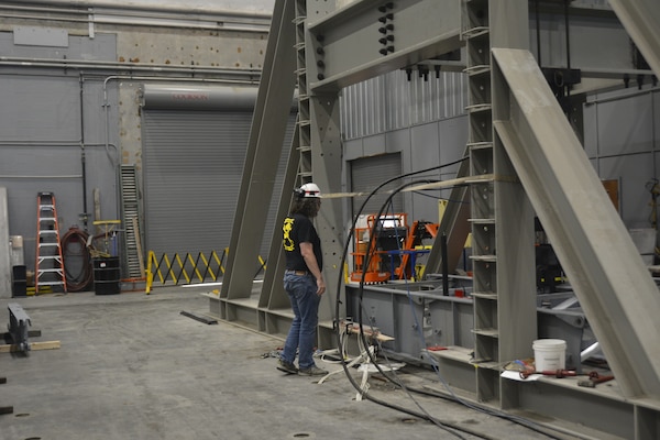 ERDC-GSL research civil engineer Dr. Kennan Crane inspects a modular ramp system at the Structural Strong Floor during testing on May 24.