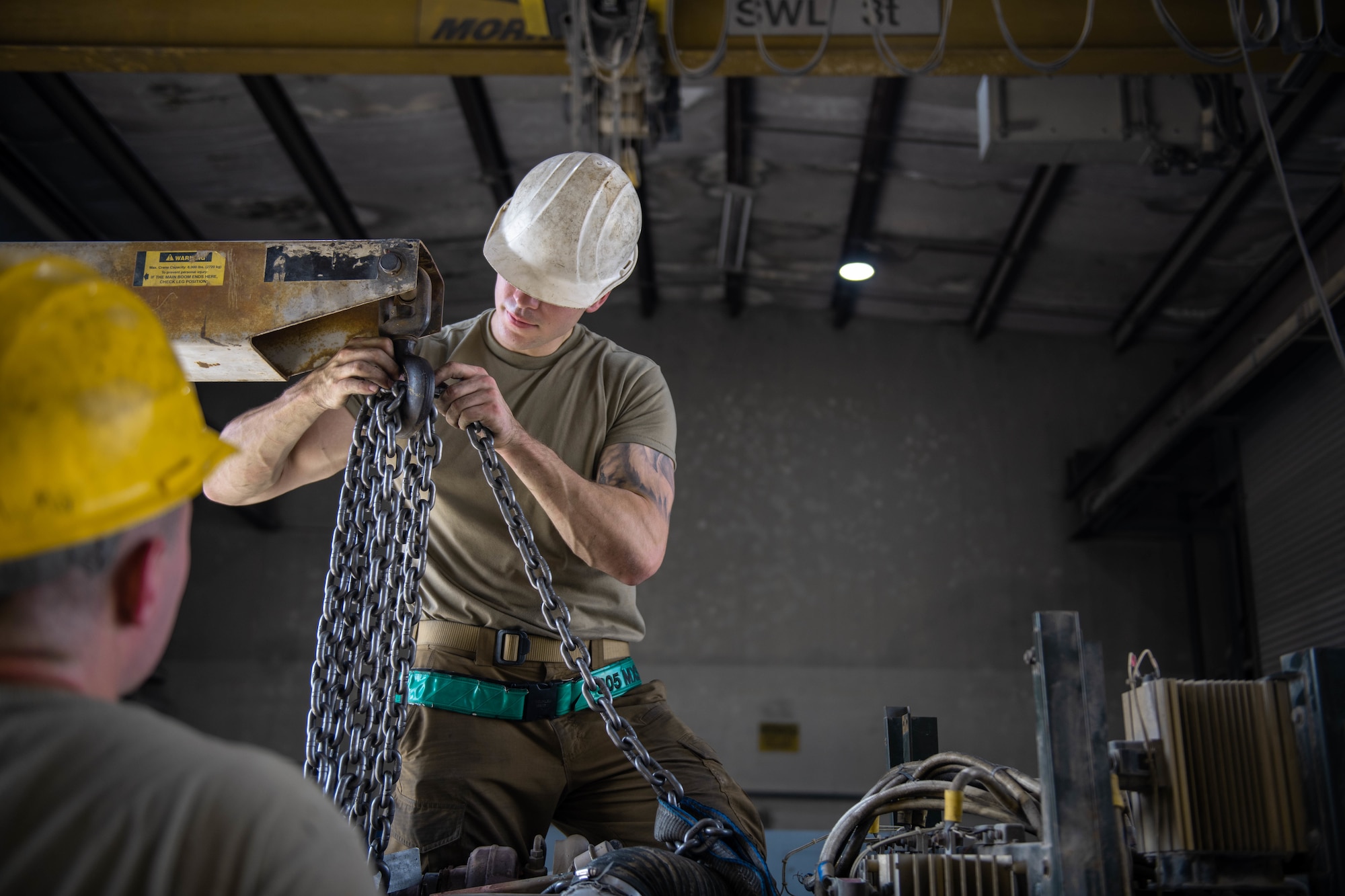 U.S. Air Force Staff Sgt. Jason Szurlej and U.S. Air Force Airman 1st Class Cameron Waters prepare to lift a generator engine out of it's chassis on Al Udeid Air Base, Qatar, June 9, 2022. Sometimes, engine maintenance requires the motor being pulled from the chassis it sits in. (U.S. Air National Guard photo by Airman 1st Class Constantine Bambakidis)