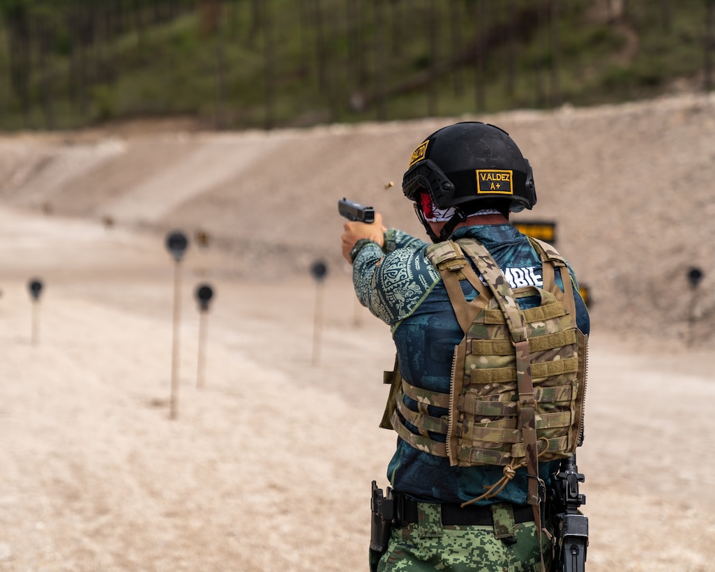 A Mexican team member fires his pistol at targets as part of Fuerzas Commando 2022.