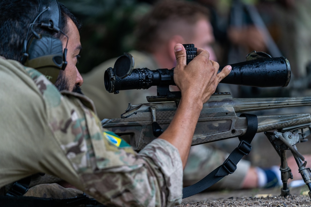A Brazilian sniper adjusts his scope during the Sniper Skill Event as part of the Fuerzas Comando 2022.
