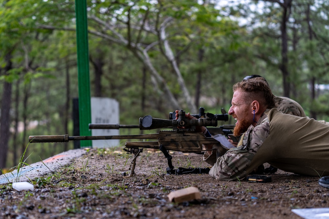 A Brazilian sniper adjusts his scope team during the Sniper Skill Event as part of the Fuerzas Comando 2022.