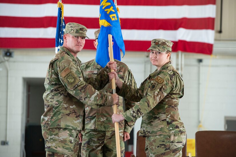 Airmen hold guidon.