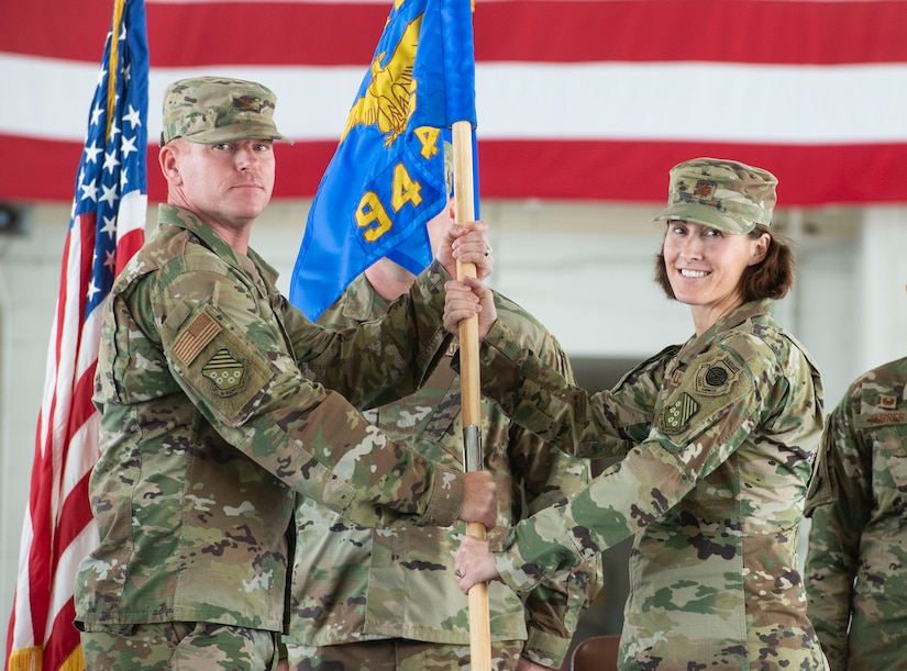 Airmen hold guidon.