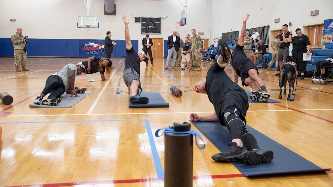 Athletes stretch and warm up on yoga mats.