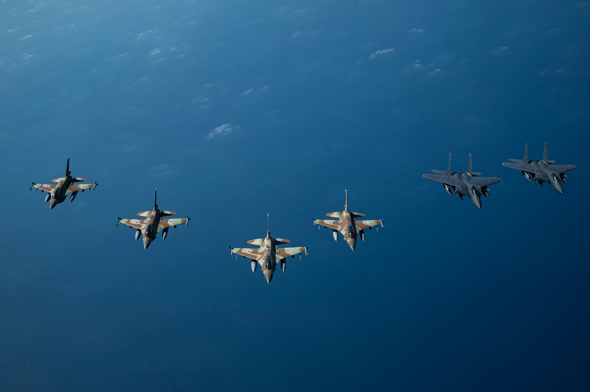 U.S. Air Force F-15 Strike Eagles fly alongside Israeli Defense Forces F-16 Barak aircraft in a formation after a successful refueling with a U.S. Air Force KC-10 Extender assigned to the 908th Expeditionary Air Refueling Squadron, within the Ninth Air Force (Air Forces Central) area of responsibility, May 18, 2022.