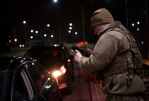 Gate guard checks I.D. at night
